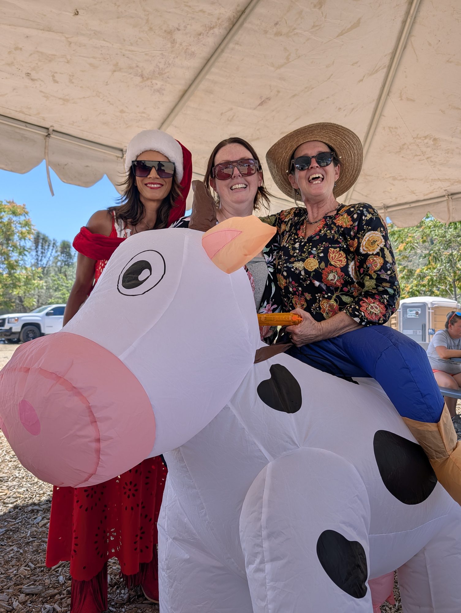 Big smiles (and one inflatable cow) under the tent.